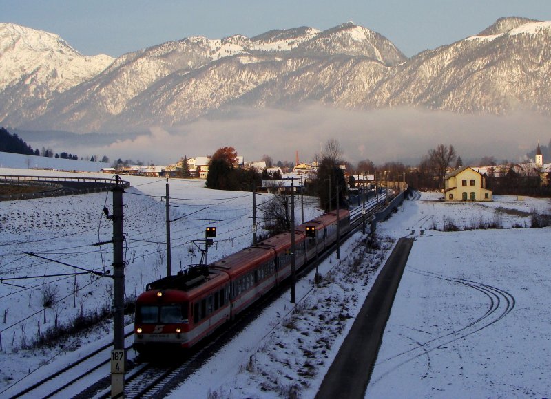 4010 016-6 verlasst die sonnige Inntal.Hinten die Berge baden schon