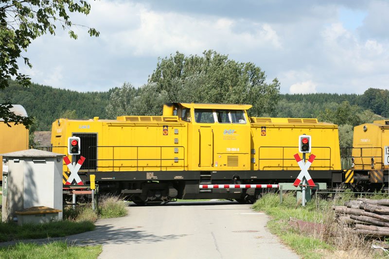 Construction train with 710-964-8 and 710-967-1; barrier at the track