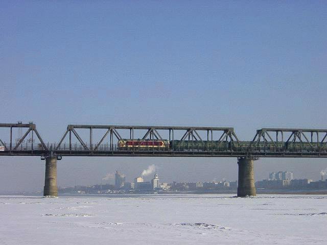 DF (vermutlich D Serie) auf der Brcke ber den zugefrorenen Songhua-Flu (Transsib-Strecke), im Hintergrund Stadteil von Harbin, Januar 2002