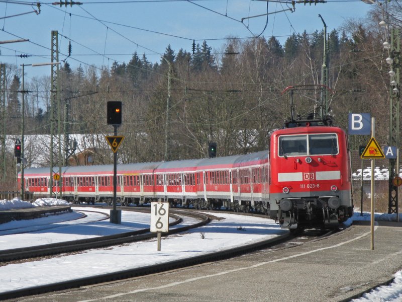 Die 111 023 fhrt an diesem sonnigen 28.Feb.2009 mit ihrer Regionalbahn nach Mnchen aus Bad Endorf aus.