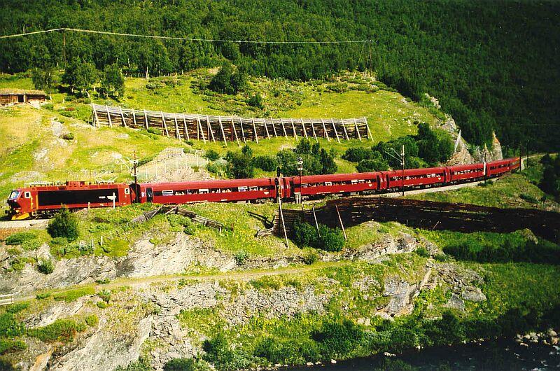 Ein Expresszug der NSB von Trondheim, bespannt mit einer El 17, hat den Bahnhof Kongsvoll passiert und berquert nun das Dovrefjell in Richtung Oslo. Die Aufnahme entstand im August 1983. 