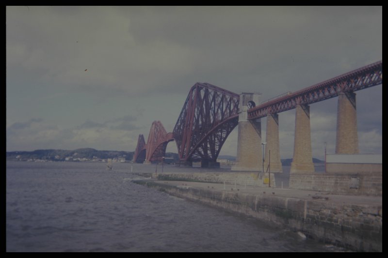 Herbst 1987. ber die gigantische Firth of Fourth Bridge nrdlich von Edinburgh fhrt ein Regionalzug. Erst wenn man ihn auf diesem Bild erkannt hat, kann man sich in etwa eine Vorstellung ber die Ausmae dieses Bauwerks machen. Eine Fahrt darber ist ein echtes Erlebnis und absolut zu empfehlen