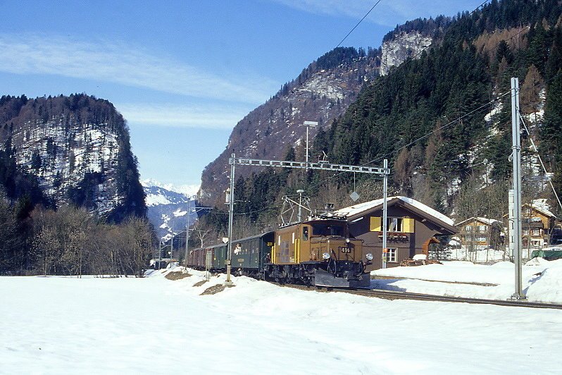 RhB Extra-GmP 3031 fr Graubndentours AG von Landquart nach Davos Platz am 14.03.1999 Durchfahrt Seewis mit E-Lok Ge 6/6I 414 - B 2246 - D 4052II - Gbkv 5568 - Gbkv 5593 - Gb 5082 - E 6610 - Kk 7070.
