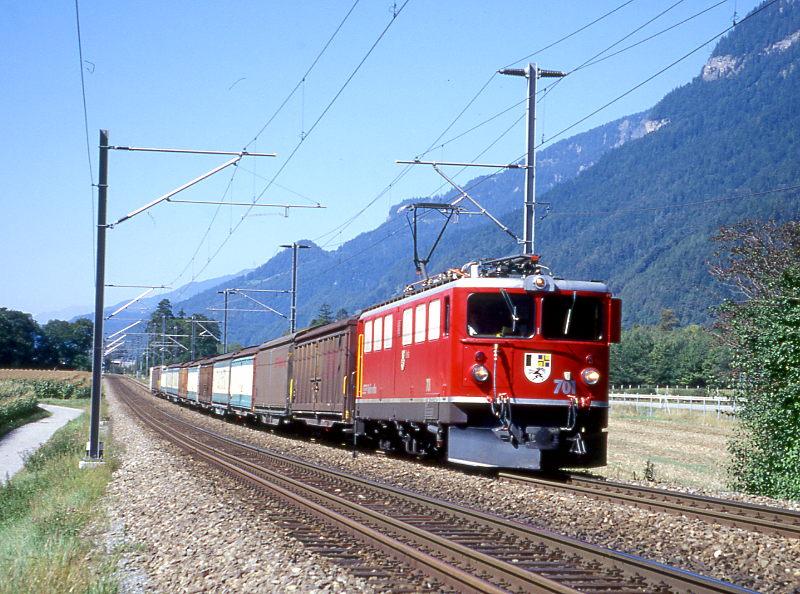 RhB Gterzug 5226 von Ilanz nach Landquart vom 26.08.1998 zwischen Felsberg und Chur mit E-Lok Ge 6/6II 701 - 10x Haikv - Uce 8003. Hinweis: dies ist ein Valserwasserzug der wegen Oberleitungsstrung bei Foral 3 Stunden Versptung hatte! Im Vordergrund ist das Dreischienengleis zu sehen, das mit Normalspur von Chur bis ins Emser-Werk fhrt.