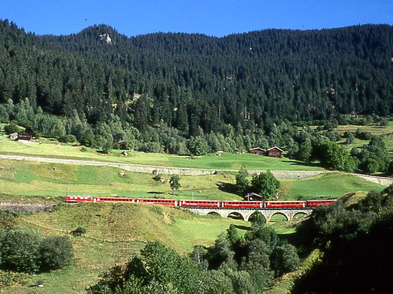 RhB Regionalzug 221 von Chur nach Disentis vom 01.09.1997 bei Compadilas mit E-Lok Ge 4/4II 603 - B 2344 - B 2348 - B 2434 - B 2351 - A 1241 - D 4213. Hinweis: Unplanmige Ge 4/4I-Lok noch mit Scherenpantografen, Blick auf Bach da Cauns-Viadukt. 