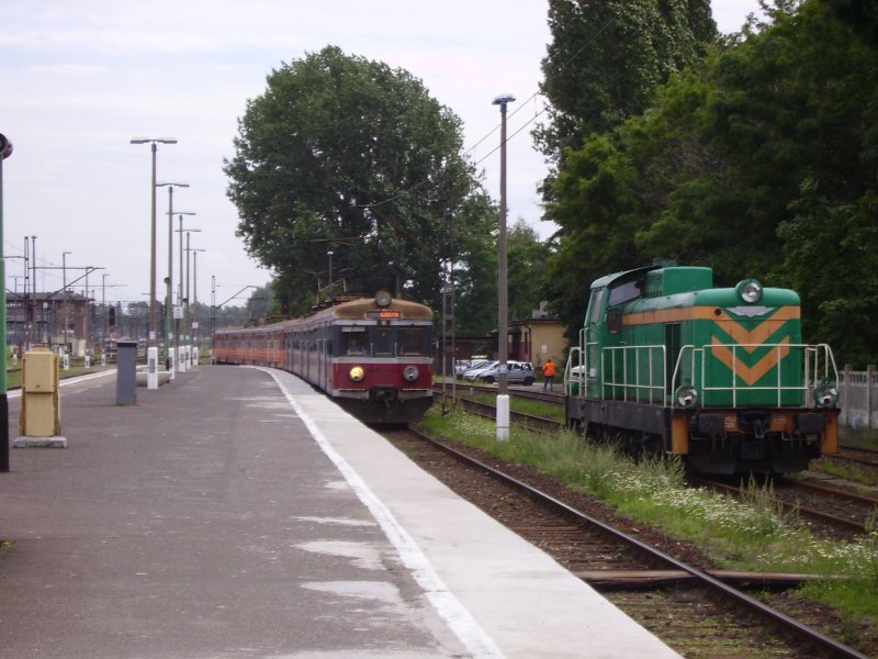 Eine EN57 f�hrt neben einer stehenden SM42 in den Bahnhof