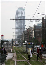 . Straßenbahnbild missglückt? -

Da hat man sich einen schönen Standpunkt und Bildausschnitt gesucht und dann laufen im entscheidenden Moment die ausgestiegen Fahrgäste ins Bild. Aber irgendwie gefällt mir das Bild dennoch. Durch die Leute wird es sehr lebendig und die als Fahrschule fahrende Flexity Outlook Tram im Hintergrund kurvt scheinbar auf Abwegen im Hintergrund herum. Die Gleisführung erinnert mich etwas an das Dach der Hamburger Elbphilharmonie. Haltestelle Porte de Flandre/Vlaamsepoort am Rande der Brüssler Innenstadt. 

23.06.2016 (M)