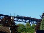 ber den Dchern von Moresnet in Belgien rollt eine BR 186 mit einem Gterzug und eingezogenen Stromabnehmern durch die Systemtrennstelle Richtung Aachen ber das 1153m lange Ghltalviadukt