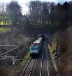 186 123 von Railtraxx kommt aus dem Gemmenicher-Tunnel aus Belgien mit einem langen KLV-Containerzug aus Genk-Goederen(B) nach Frankfurt-Höchstadt am Main und fährt nach Aachen-West und rollt die Gemmenicher-Rampe herunter nach Aachen-West. Aufgenommen in Reinartzkehl auf der Montzenroute bei schöem Sonnenschein am Nachmittag vom 28.2.2015.