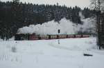 Bei d�sterem Winterwinter f�hrt 99 7234-0 mit ihrem Zug, durch ...