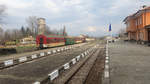 Rhodopenbahn im Bf Bansko (Банско) am 26.03.2017 um 17:53 Uhr. 
Zug wartet auf Abfahrt (17:58 Uhr) Richtung Dobrinischte (Добринище).
Auf dem Bahnsteig weht neben der Bulgarischen auch die EU-Fahne.