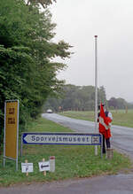 Sporvejsmuseet Skjoldenæsholm / das Dänische Straßenbahnmuseum: Impressionen aus dem 16. August 1992. - Vor der Besuchszeit muss in Verbindung mit dem  Klarmachen  des Museums u.a. die Flagge gehisst werden. - Nach der Legende empfingen die Dänen 1219 ihre Flagge  Dannebrog  (dt.  Danebrog ), die älteste Nationalflagge der Welt, in einer Schlacht bei Lyndanise in Estland; die Flagge, die rot mit einem weißen Kreuz ist, soll vom Himmel herabgefallen sein. - Scan eines Farbnegativs. Film: Kodak Gold 200-3. Kamera: Minolta XG-1.