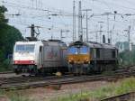 Deutschland --- Belgien Crossrail-Teamarbeit im Umsetzbahnhof Aachen-West. Hier stehen 185 580-8 und DE6606 Seite an Seite. Die 185er wird den Containerzug �bernehmen, den die Class 66 zuvor aus Belgien gebracht hat, und weiter Richtung K�ln bef�rdern, w�hrend die Diesellok ihrerseits den aus K�ln �berbrachten anderen Containerzug �ber die Montzenroute nach Belgien ziehen wird. Aufgenommen am 28/07/2010.