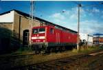 112 169 im Oktober 1998 vor dem Lokschuppen 3 im Bw Stralsund.Die Lok wurde dann vom Akkuschleppfahrzeug(ASF)101 im Hintergrund abgeholt und in einem stromlosen Lokstand vom Schuppen 3 abgestellt.