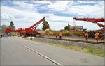 Bauzug-Entgleisung Radolfzell. Noch mehrfach hat es ordentlich geknackt, bis der Zug nun fast gerade steht. Man sieht wieder eine Staubwolke, die dabei aufgewirbelt wurde. Juli 2016. 

Standort des Fotografen auf öffentlicher Straße hinter der Absperrung der Polizei.