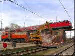 Whrend die Bagger den Mittelpfeiler des Kreuzungsbauwerk in Falkenberg/Elster abtragen, geht der Verkehr darauf ungehindert weiter (143 831 mit RE10 nach Leipzig).