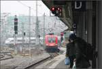 Großstadtbahnhof-Atmosphäre -    Einfahrt des Zuges, Gleis- und Oberleitungswirrwar des Vorfeldes, wartende Reisende auf dem Bahnsteig...