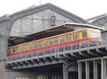 Blick vom Spreeufer auf Bahnhof Berlin Friedrichstraße auf einen Richtung Berlin Hbf ausfahrenden S-Bahn-Triebwagen (Oktober 2014)