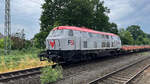 FSI 216 121-4 am 20. Juni 2023 mit Schotterzug bei der Durchfart im Bahnhof Bohmte, Fahrtrichtung Osnabrück.