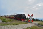 99 7232-4 kommt mit einem Zug Richtung Tal über den ersten Bahnübergang hinter dem Bahnhof Brocken gefahren. Hier hat sie bereits eine Ehrenrunde um den Brocken gefahren.

Brocken 22.07.2016