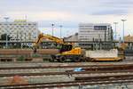 Ein Zweiwegebagger der Jaeger Umwelt + Verkehr GmbH + Co KG mit Schotter am Haken rollt Richtung Ostseite von Halle(Saale)Hbf, die sich noch im Umbau befindet. [9.9.2017 - 8:23 Uhr]