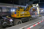 Nachts im Bahnhof Konstanz - Der von der Firma SPITZKE eingesetzte Zweiwegebagger ATLAS 1604KZW schaufelt den Gleisschotter unter der inzwischen entfernten Weiche von Gleis 2 in die bereitgestellten