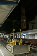 Nachts im Bahnhof Konstanz - Die von der Firma SPITZKE eingesetzte Planierraupe CAT D5G wartet auf Gleis 2 darauf, dass der hinter der Raupe liegende Altschotter, auf der eine Weiche lag, entfernt und mit Neuschotter aufgefüllt wird (06.08.2016).