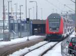 Der Endpunkt Norddeich Mole am 06.02.2010 mit einem Schiff im Hintergrund und einem RE am Bahnsteig.