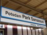 Der Bahnhof Potsdam Park Sanssouci mit Bahnhofsschild.