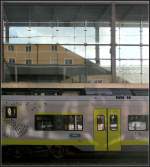 Spiegelung und Lichtreflexion -     Das alte Bahnhofsgebäude vom Hauptbahnhof Regensburg spiegelt sich im neuen Bahnsteig-Zugang-Bauwerk; Lichtreflexionen fallen auf den Coradia Contiental