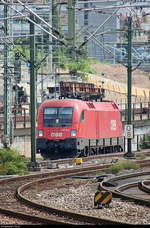 Tele-Blick auf 1116 184 (Siemens ES64U2) ÖBB, die im Gleisvorfeld von Stuttgart Hbf abgestellt ist und zwischen zwei Masten  eingepasst  wurde.