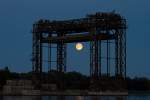 Aufgehender Vollmond steht hinter dem Historischen Denkmal der Eisenbahnhubbrcke Karnin.