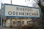 Bahnhofsschild Rheydt-Odenkirchen im Hintergrund sieht man die Reste des ehemals stolzen Bahnhofsgebudes.