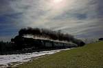 Die Dampflokomotive 01 1066-7 donnert mit einer herrlichen Rauchfahne im Gegenlicht bei einer von starken Schleierwolken geprägten Wetterstimmung die Steigung bei Schlachters hoch,Diesellok
