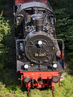 Die Dampflokomotive 38 2267 kämpft sich durch das satte Grün auf der Strecke der Ruhrtalbahn, so gesehen im September 2023 in Hattingen-Welper.
