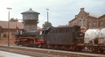 Im Sommer 1976 wartet die 042 024-0 mit einem Güterzug im Bahnhof Lingen auf die Ausfahrt in Richtung Norden, im Hintergrund der Wasserturm des dortigen Ausbesserungswerkes.