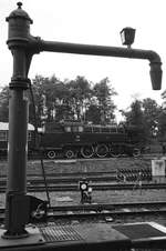 Der Wasserkran auf den Gelände des Eisenbahnmuseums Bochum-Dahlhausen, einige Gleise dahinter die 66 002. (September 2016)
