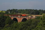 Eine SWT V100 in orange mit Schrottzug auf der ELstertalbrücke bei Jocketa.