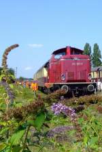 212 007-9 (V100.20) mit historische Rheingoldwagen hinter Sommer-Flieder am 14.08.2010 im Rheinisches Industriebahn-Museum (RIM) in Kln.