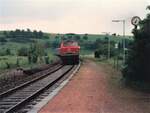 215 055-5 fährt ca. 1986 in den Bahnhof Hausen vor Wald ein. Auf dem Bahnsteig sichtbar Stationsschild und Uhr.