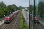 Versuch, den sich auf der Verglasung des Aufzuges der Fußgängerüberführung spiegelnden Zug zusammen mit dem direkt zu fotografierenden Zug in einem Bild festzuhalten. 218 427-3 durchfährt mit den Wagen des IRE 4215 von Stuttgart nach Lindau die Haltestelle Biberach Süd (31.07.2017).