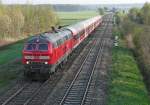 Auf der Fahrt von Ulm nach Lindau wird 218 487-7 mit dem aus n-Wagen zusammengestellten RE 3239 gleich unter der im Schenkenwald stehenden Brücke durchfahren (Nähe Mochenwangen, 25.04.2014).