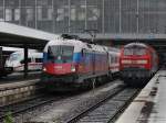 Die 1116 084 (EM Russland) mit einem EC und die 218 400 mit der RB aus Mhldorf am 16.05.2009 in Mnchen Hbf.