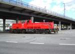 Verkehrsrot auf der Strae: die Gravita 261 097-0 unterquert am 10.07.2013 um etwa 17:00 Uhr auf der Rckfahrt von einer bergabe an den Bollhrnkai die Gablenzbrcke in Kiel.