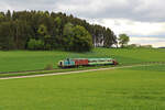 Im Frühjahr 2023 kam bei der Chiemgauer Lokalbahn ein Ersatzzug zum Einsatz. Zuglok war RCC 360 106-9, während am Zugschluss die 323 699-9 der Chiemgauer Lokalbahn hängt. Hier dieselt der Zug gerade zwischen Aindorf und Amerang in Richtung Bad Endorf. (18.05.2023)