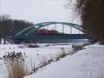 An einem trben, kalten Wintertag passiert eine BR 145 mit leeren Autotransportwaggons bei Bchen die Brcke ber den Elbe-Lbeck-Kanal in Richtung Boizenburg; 20.02.2010  