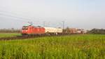 DB Cargo 185 012 fährt mit mit EZ 51024 Maschen Rbf - Hagen-Vorhalle an einem teilweise blühenden Rapsfeld vorbei (Marl, NI, 11.01.2020).