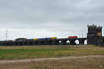 Die DB-Elektrolokomotive 185 374-6 zieht einen Containerzug über die Hochfelder Eisenbahnbrücke, so gesehen Ende August 2022 in Duisburg.