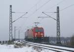 185 321-7 mit einem Aufliegerzug Richtung Maschen am 15.02.2009 bei Osterrnfeld.