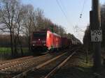 185 261-5 mit einem Gterzug zwischen Rheine und Emden bei Devermhlen (B 296.6) am 23-3-2012.